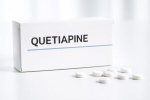 Quetiapine medicijndoos en tabletten op een witte achtergrond – informatie over gebruik en werking.